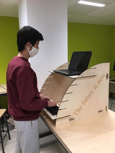 The hard work at our Student Computer Innovations and Fabrication Institute (SCIFI) continued all the way up to the end of the school year. The latest project of the ACS innovators aimed to help alleviate fatigue associated with prolonged sitting at a desk in the context of distance learning. To achieve the task at hand, the creators used the facilities at our makerspace, situated at the foot of the America for Bulgaria Campus Center. Equipped with a laser-cutter, 3D printers, Computer-Assisted Design facilities, and a carpentry workshop, SCIFI provides the students with opportunities to help our community, with the added benefit of learning while doing so.  The SCIFI Makers have come up with a creative approach to alleviating fatigue: stand-up desks. Ergonomic solutions like these have become increasingly popular worldwide and offer the laptop (or Chromebook) users to work with their devices while standing up for a stretch.  Several ACS teachers initiated the production of such desks at SCIFI. David Yordanov, the manager of the Institute, shared that the idea was born on a 100+ km cycling trail where he and some ACS colleagues discussed the benefits of stand-up desks. “We got to the conclusion that it will be great to prototype one in our makerspace.”